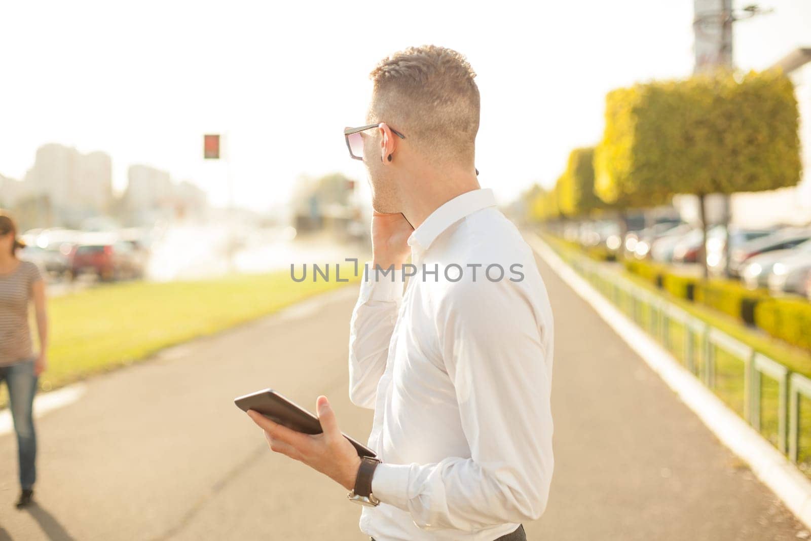 Businessman Man With Mobile Phone and Tablet computer in hands, In City, Urban Space