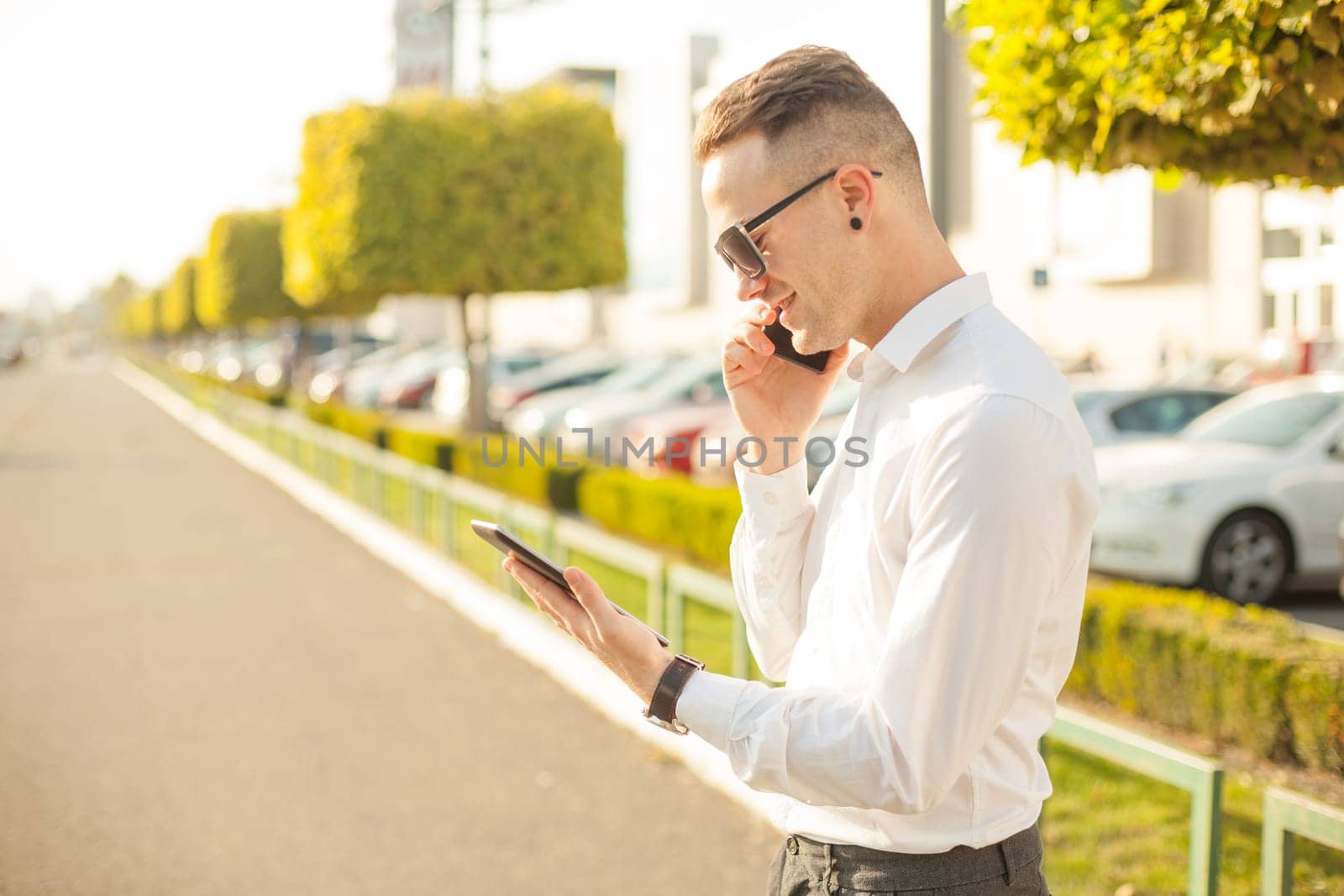 Businessman Man With Mobile Phone and Tablet computer in hands, In City, Urban Space