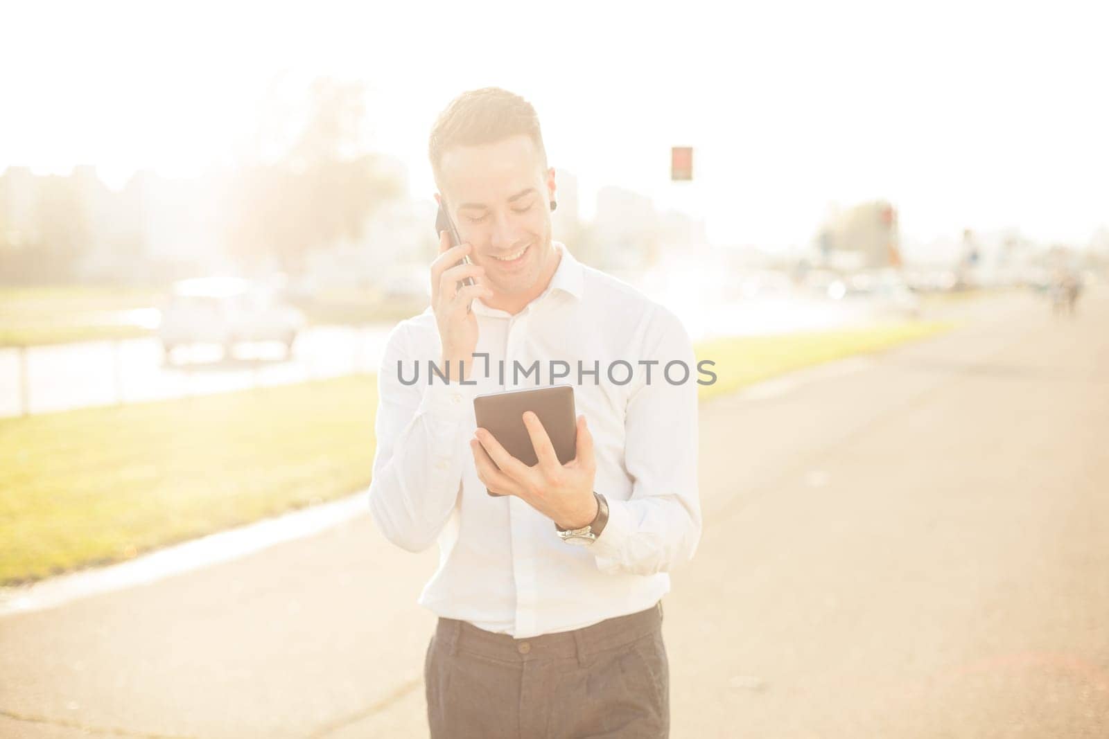 Businessman Man With Mobile Phone and Tablet computer in hands, In City, Urban Space