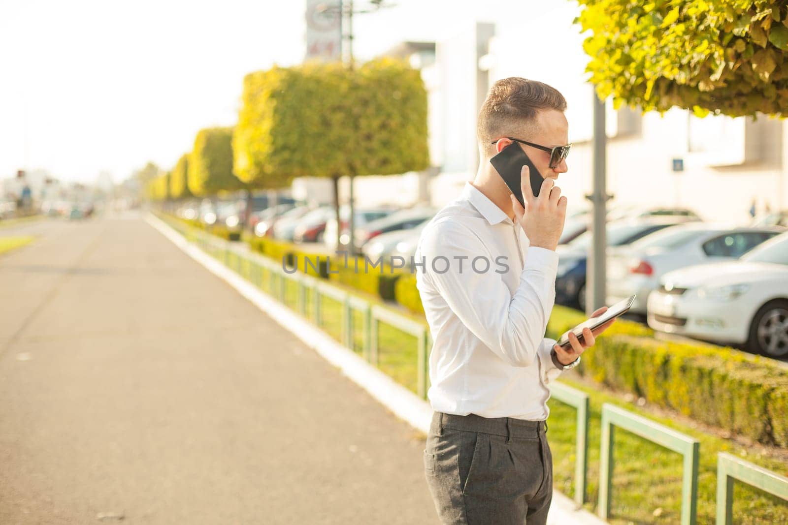 Businessman Man With Mobile Phone and Tablet computer in hands, In City, Urban Space