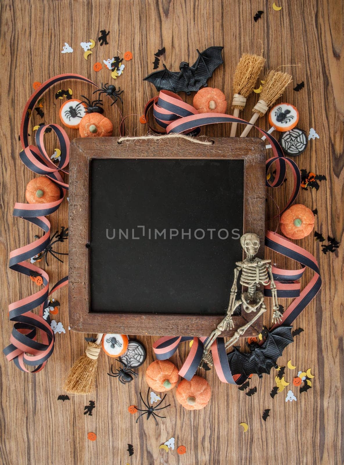 Colorful decoration and sweets for Halloween on background made of wood