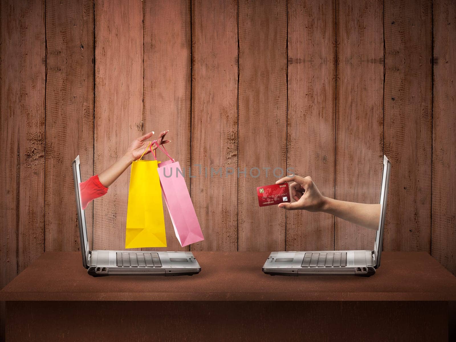 Hand out from computer carry shopping bag, the other show credit card. Online shopping conceptual