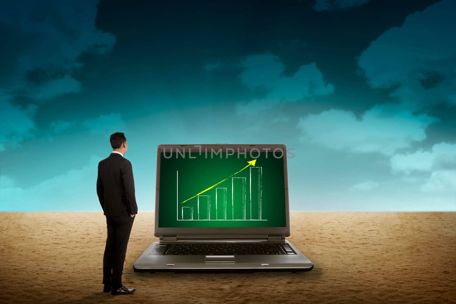 Business person looking giant laptop on the desert. Wireless concept