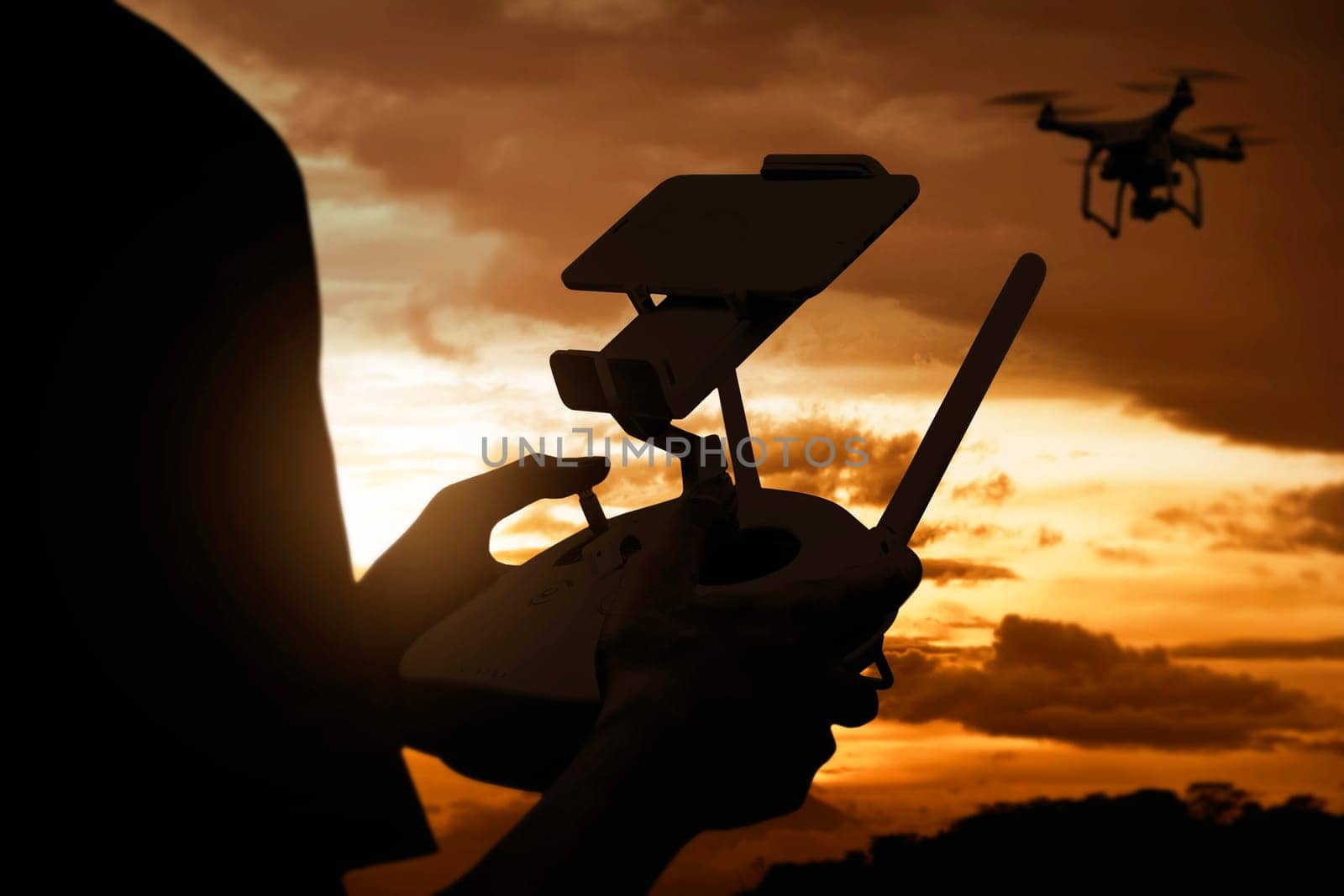 Man playing with drone with sunset sky background