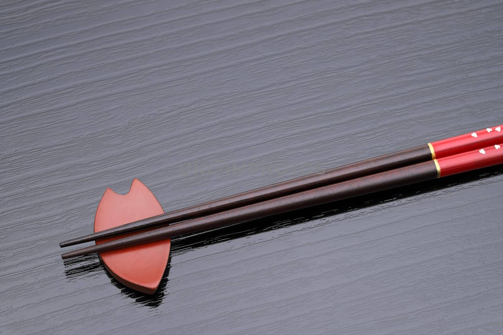 Chopsticks and chopsticks rest on black table background