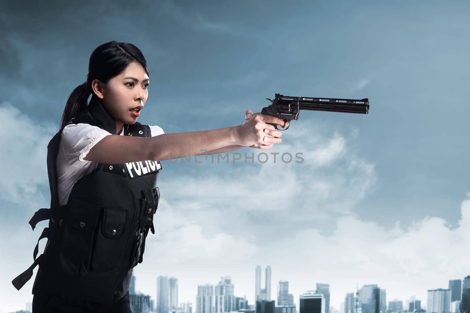 Beautiful police woman holding gun ready to fire
