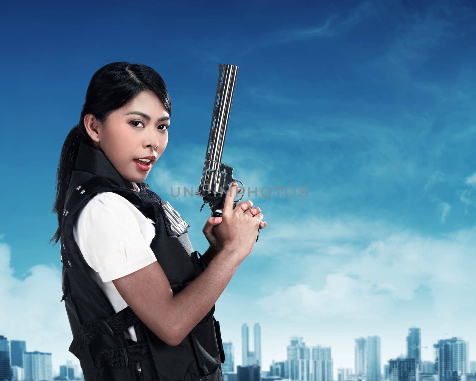 Beautiful police woman holding gun ready to fire