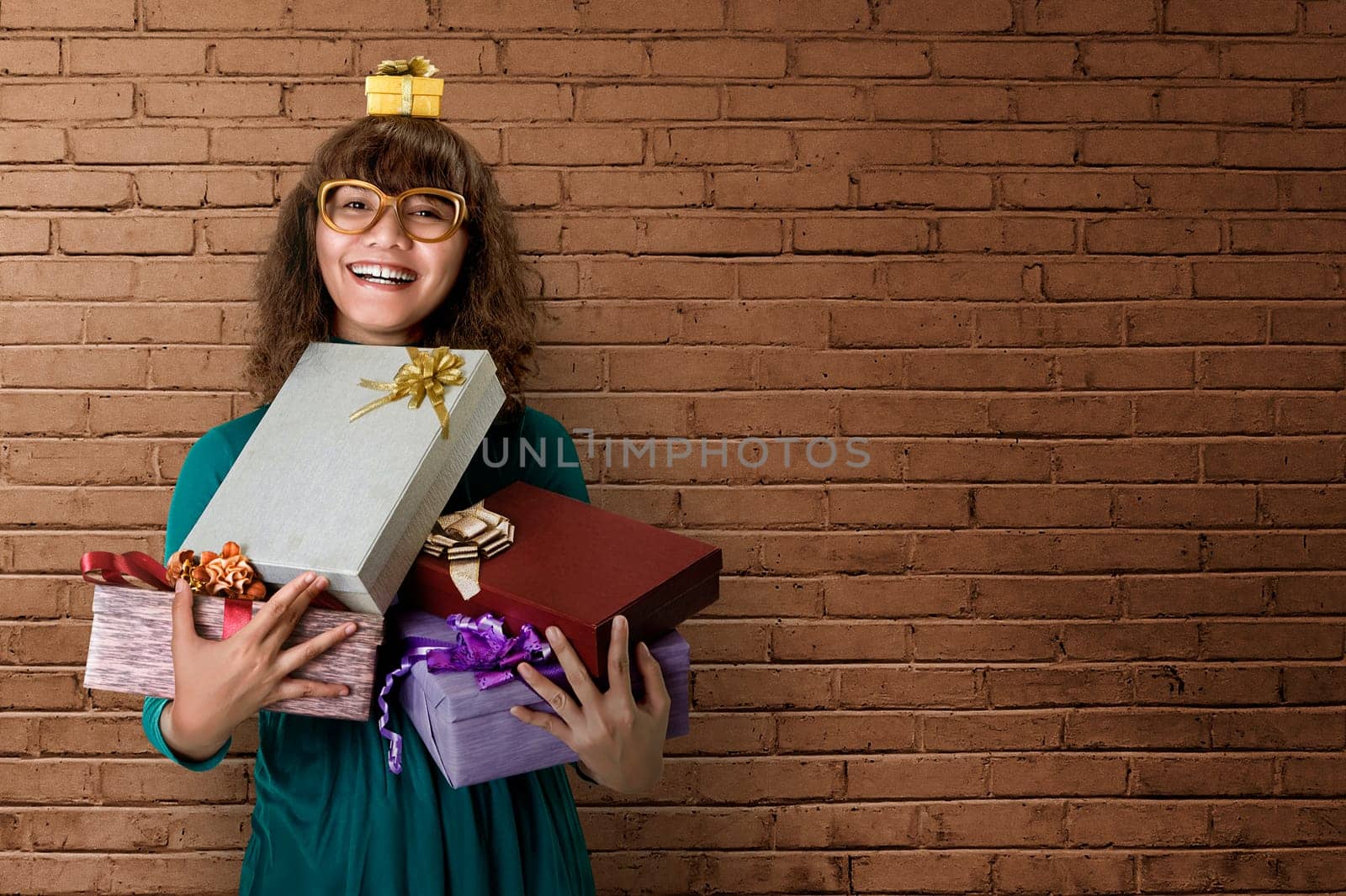 Asian woman smiling full of excitement, with a few gifts in her hands