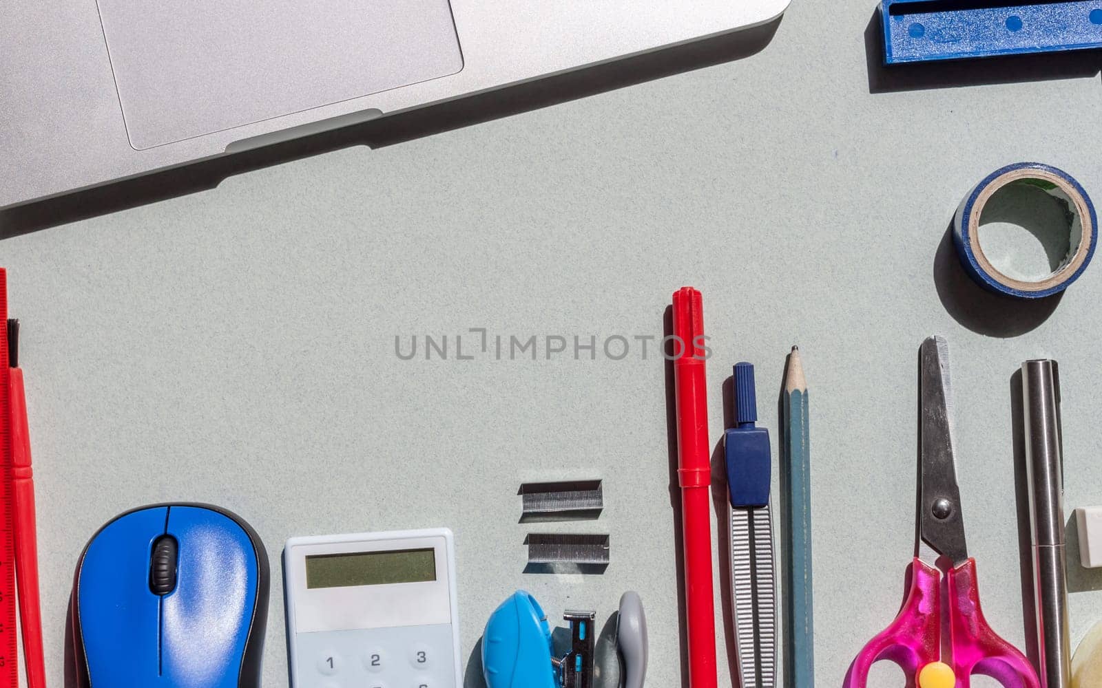 school stationery on blue paper background with copyspace