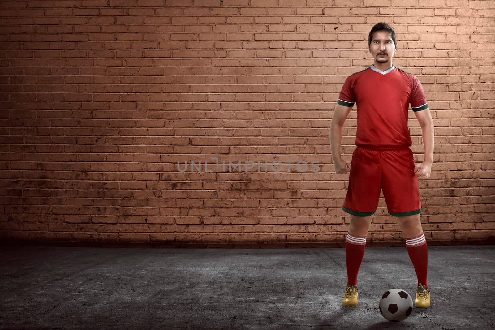 Asian football player standing on the alley ready playing street soccer
