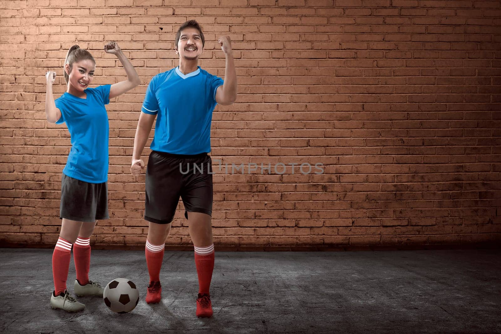 Image of young couple playing street soccer together