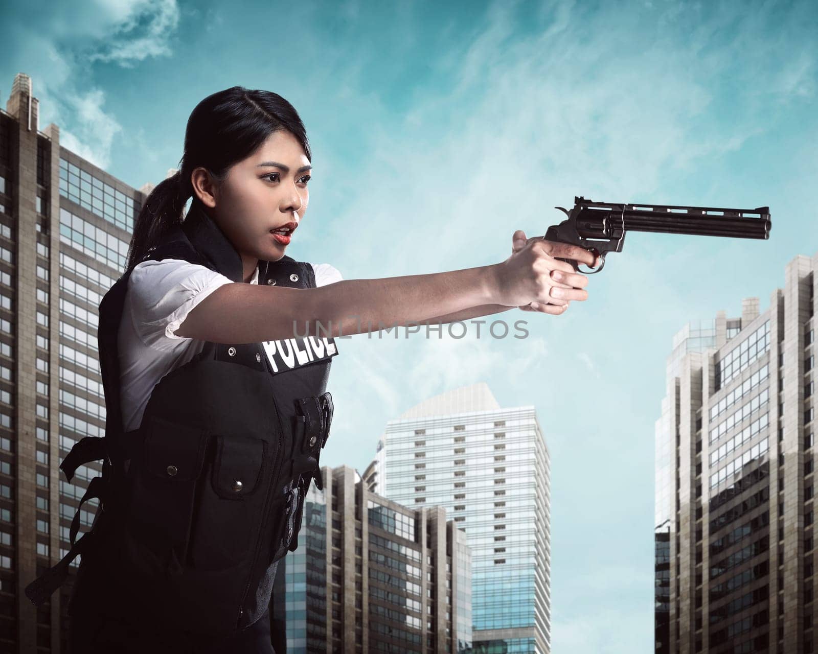 Beautiful police woman holding gun ready to fire