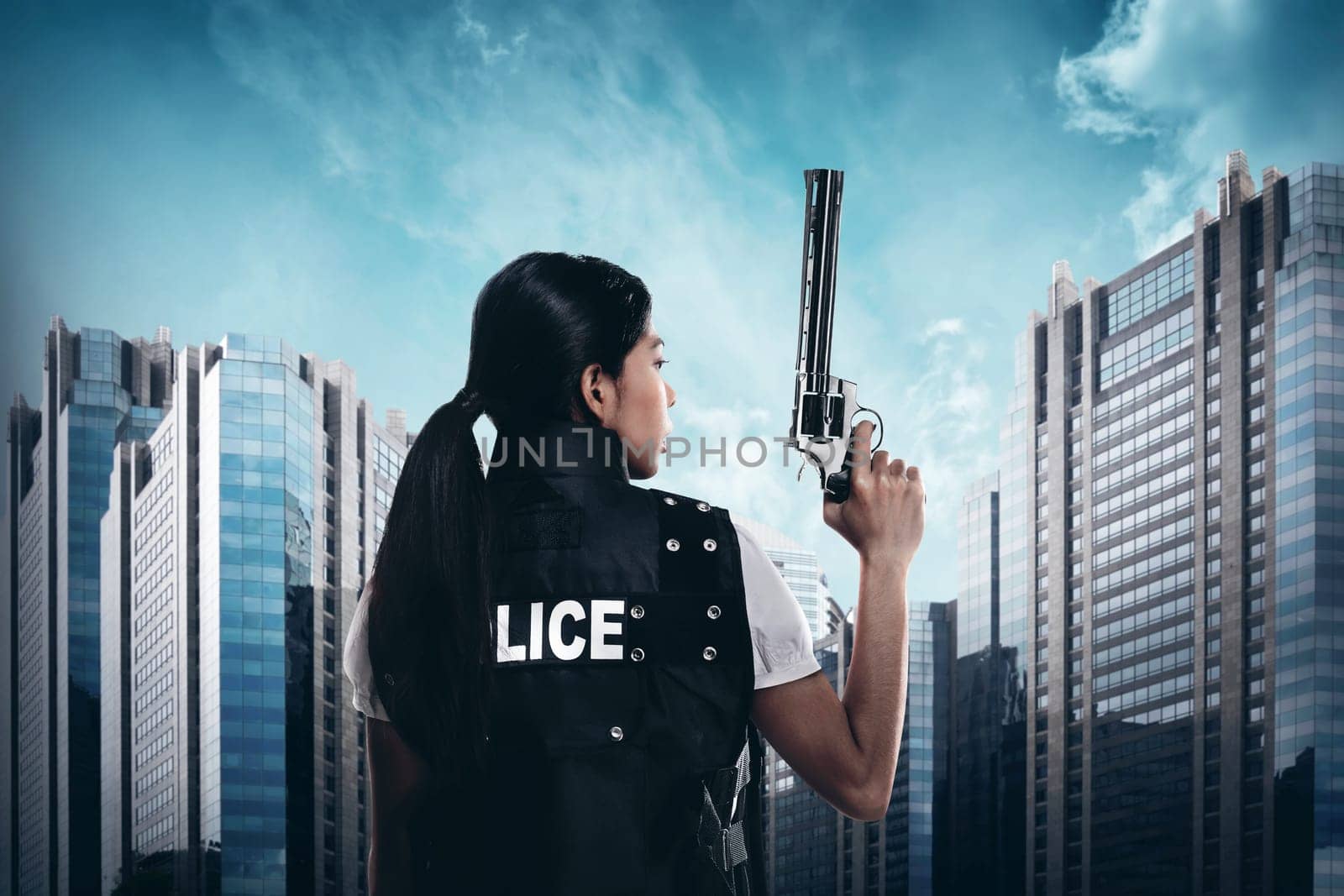 Beautiful police woman holding gun ready to fire