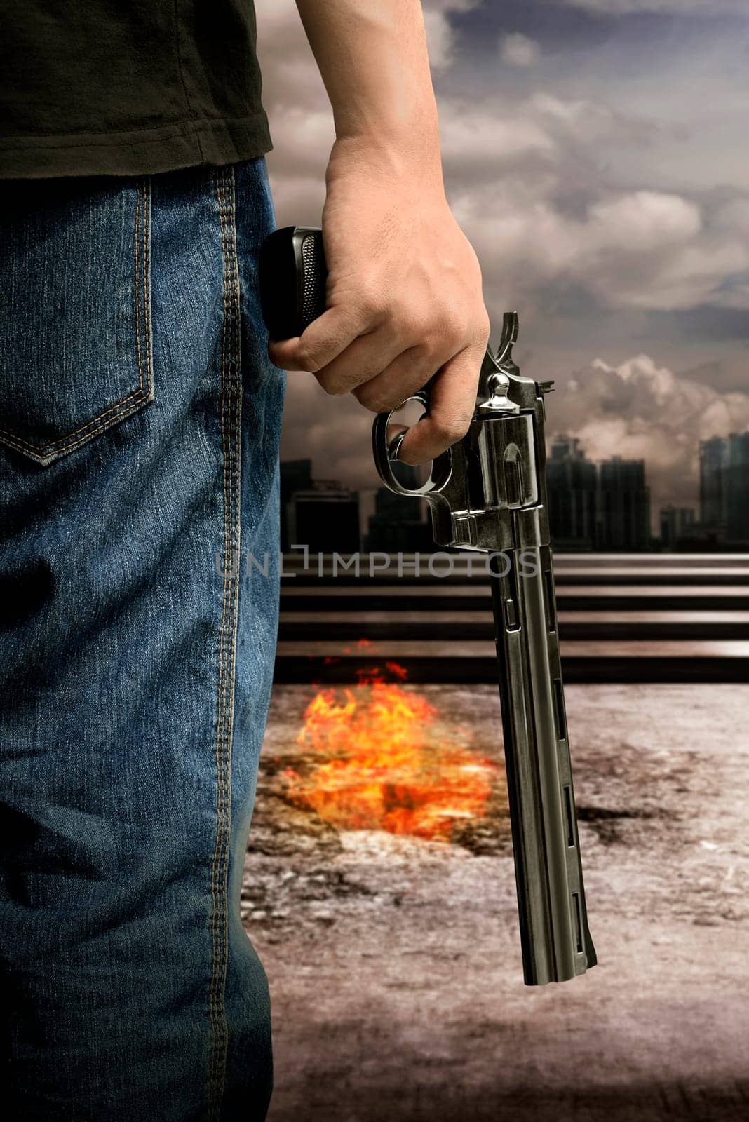 Man hand holding gun with burn city background