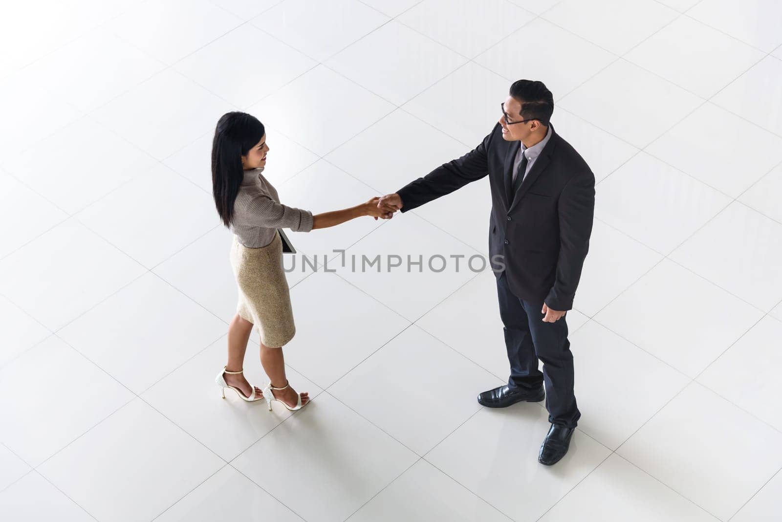 Top view, Asian business people, man and woman, greeting by smiling and shaking hands