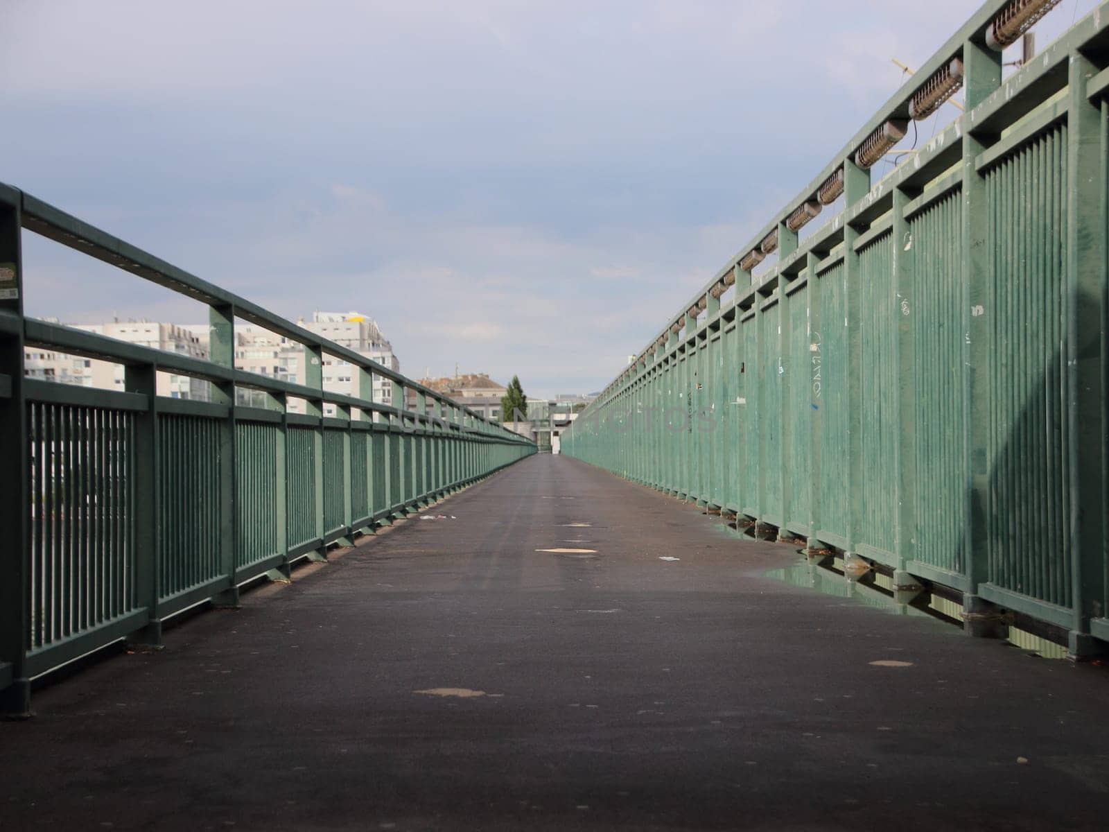Very long Asphalt Footpath with Green Metal Banisters Perspective
