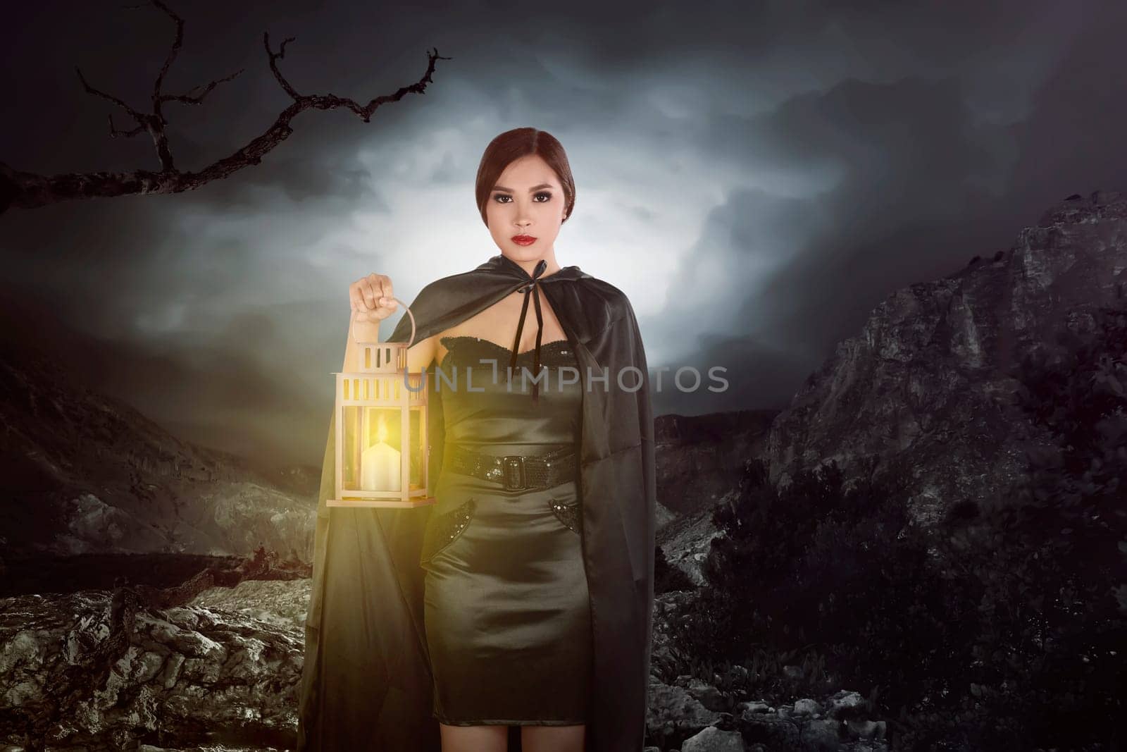 Asian witch woman with a lantern walking on rock hill