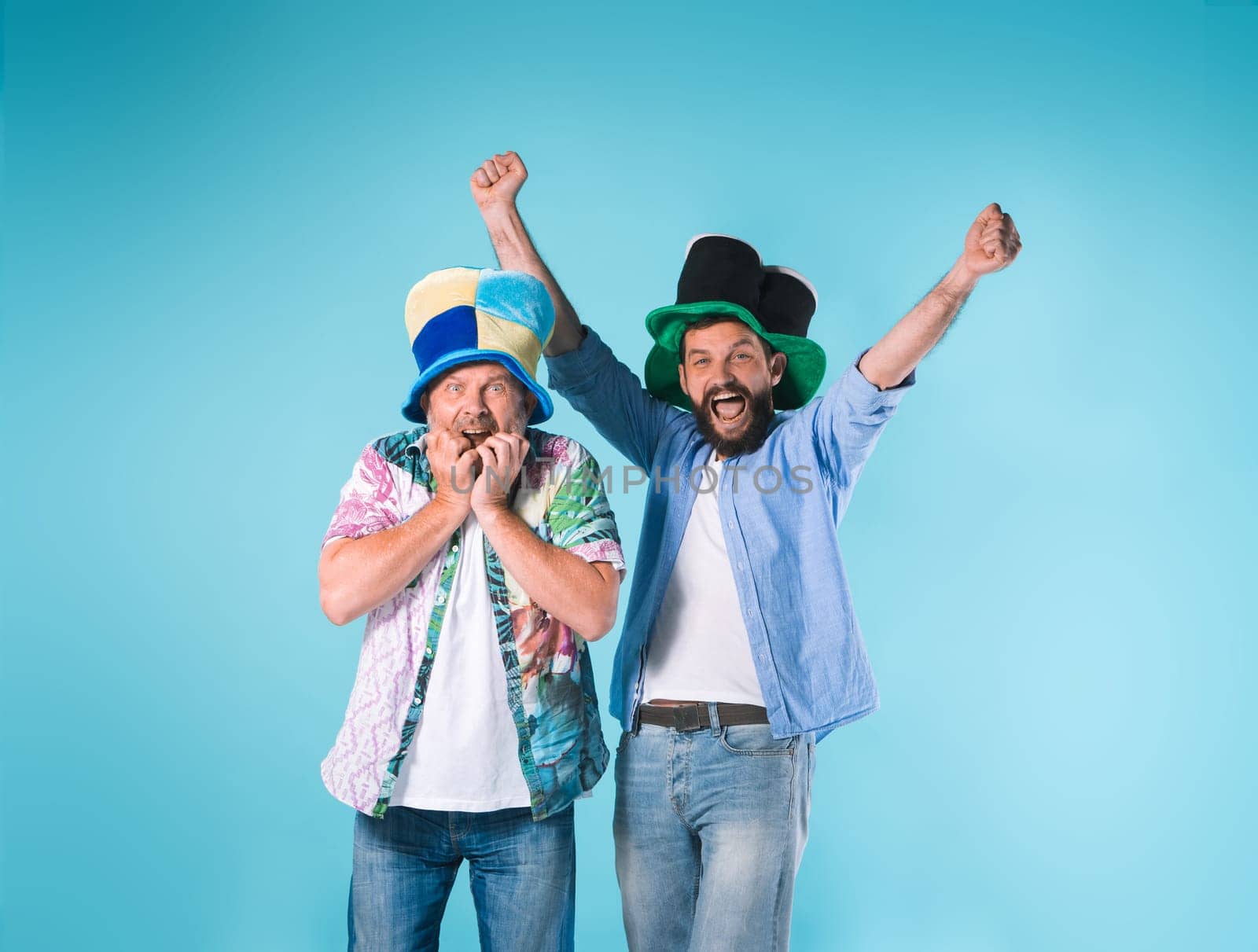 The two emotional football fans over blue background