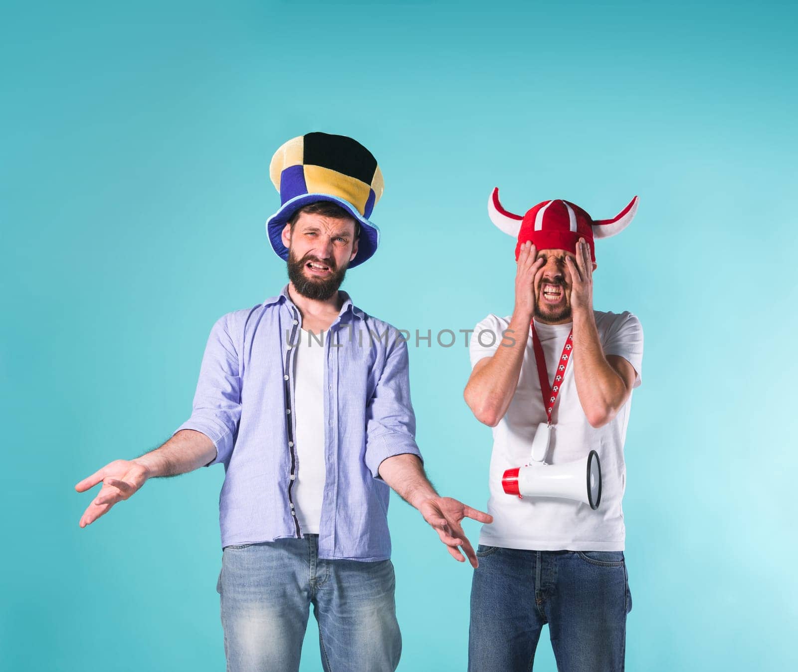 The two football fans with emotions of disappointment over blue background
