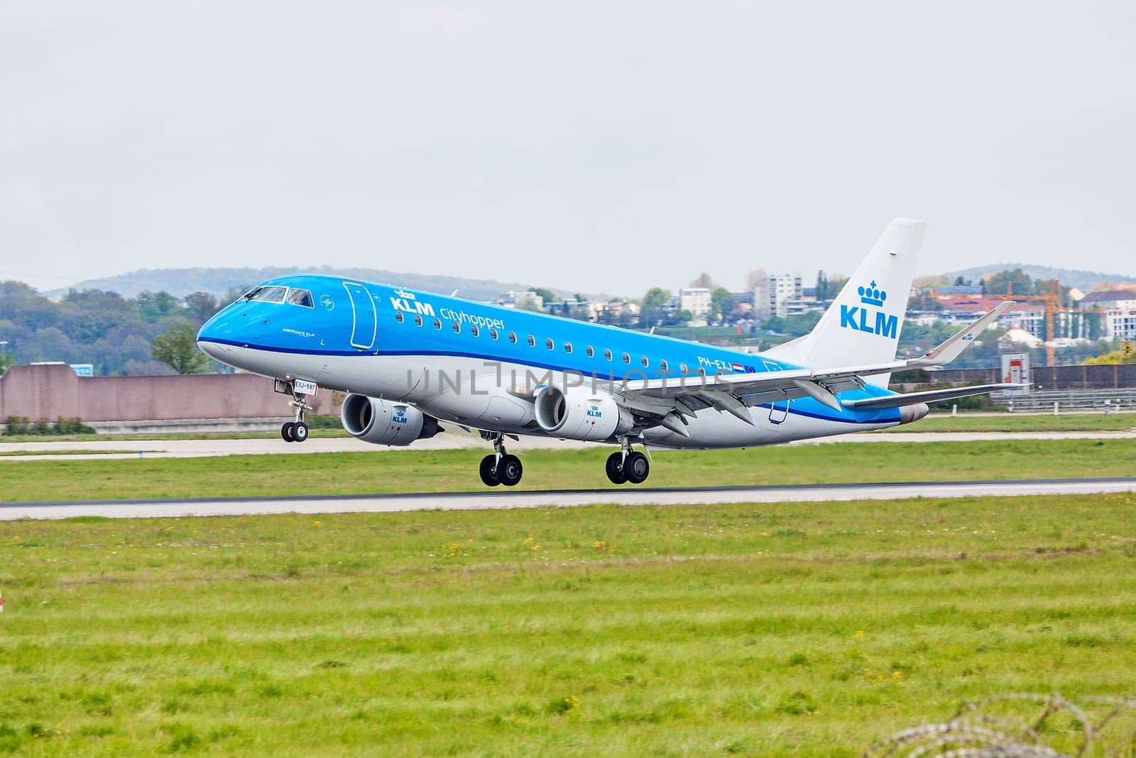 Stuttgart, Germany - April 29, 2017: Airplane Embraer ERJ-175 from KLM cityhopper during landing - green meadow in front