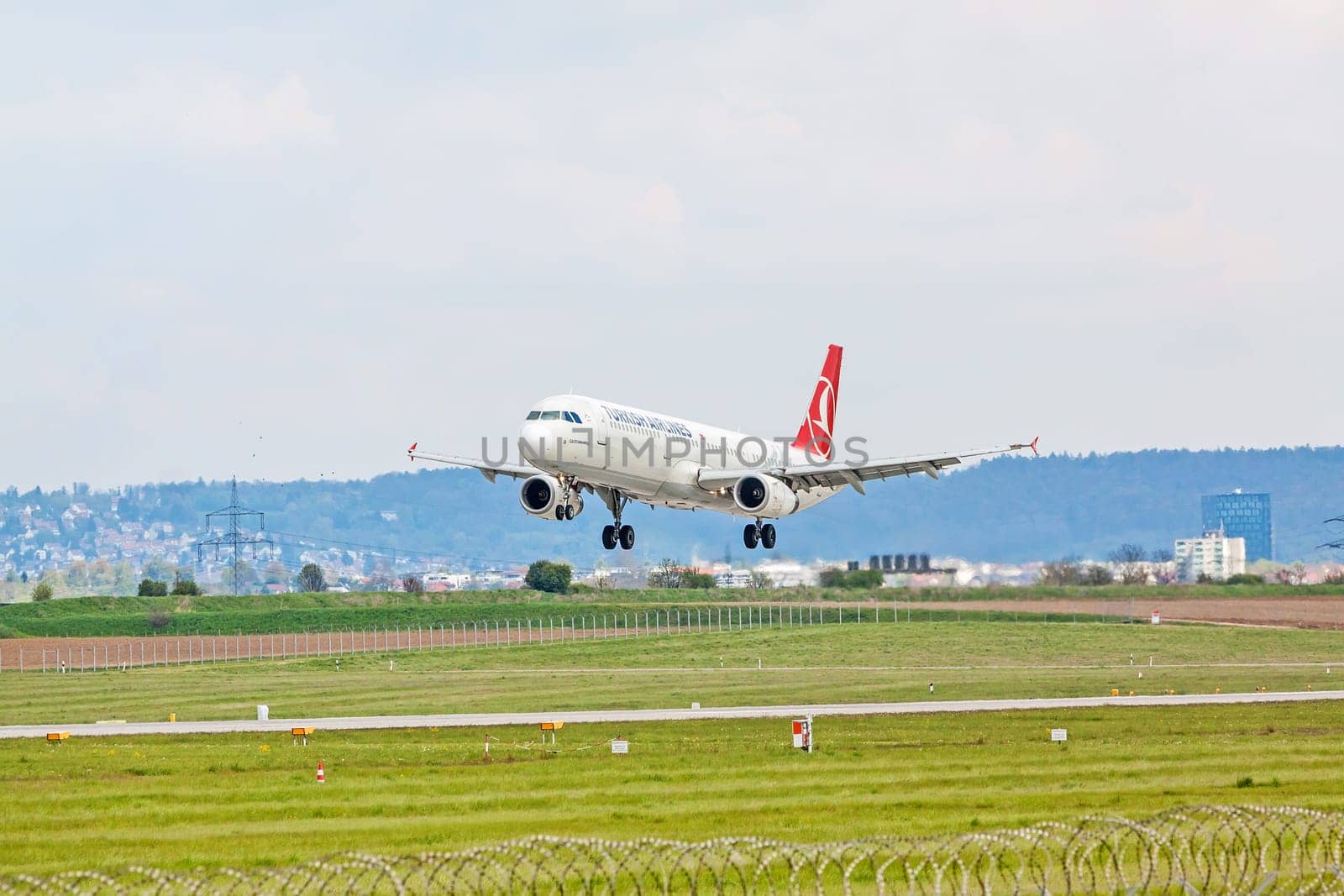Stuttgart, Germany - April 29, 2017: Airbus airplane A321 from Turkish Airlines on landing approach at airport Stuttgart - runway and green meadow in front