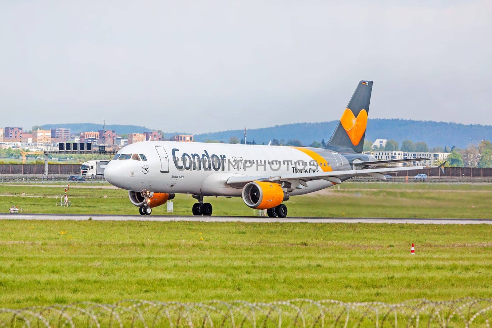 Stuttgart, Germany - April 29, 2017: Airbus airplane A320 from Condor at ground (airport Stuttgart) before takeoff - green meadow with fence in front