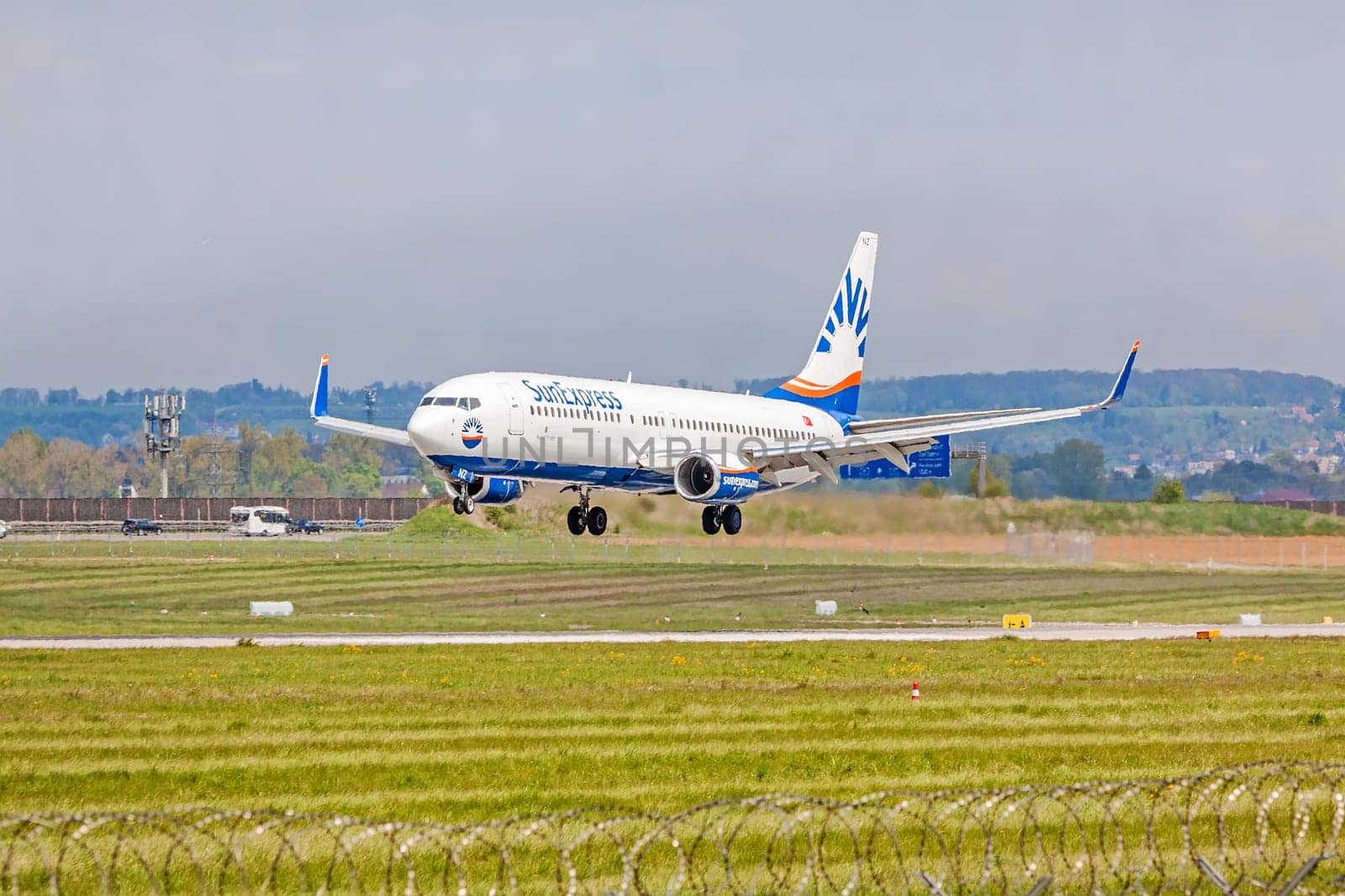 Stuttgart, Germany - April 29, 2017: Boeing 737 airplane from SunExpress airline on landing approach to airport Stuttgart - green meadow with fence in front