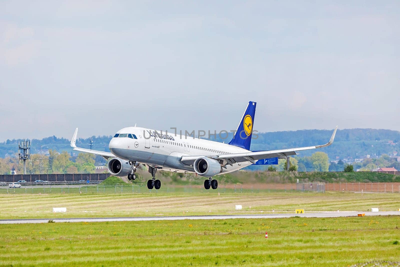 Stuttgart, Germany - April 29, 2017: Airbus airplane A320 200 from Lufthansa on landing approach to airport Stuttgart - runway and green meadow in front