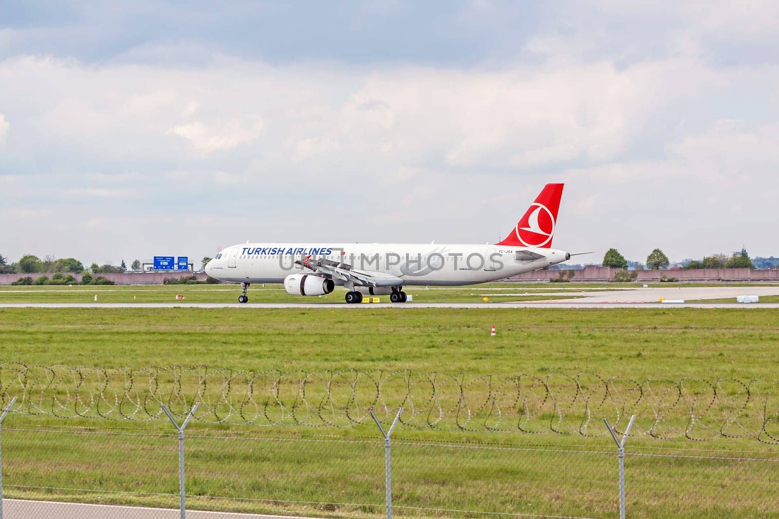 Stuttgart, Germany - April 29, 2017: Airbus airplane A321 from Turkish Airlines on landing approach at airport Stuttgart - runway and green meadow with fence in front