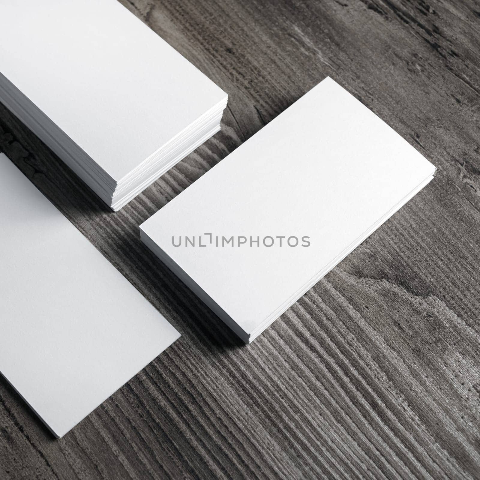 Photo of blank paper business cards on wooden background.