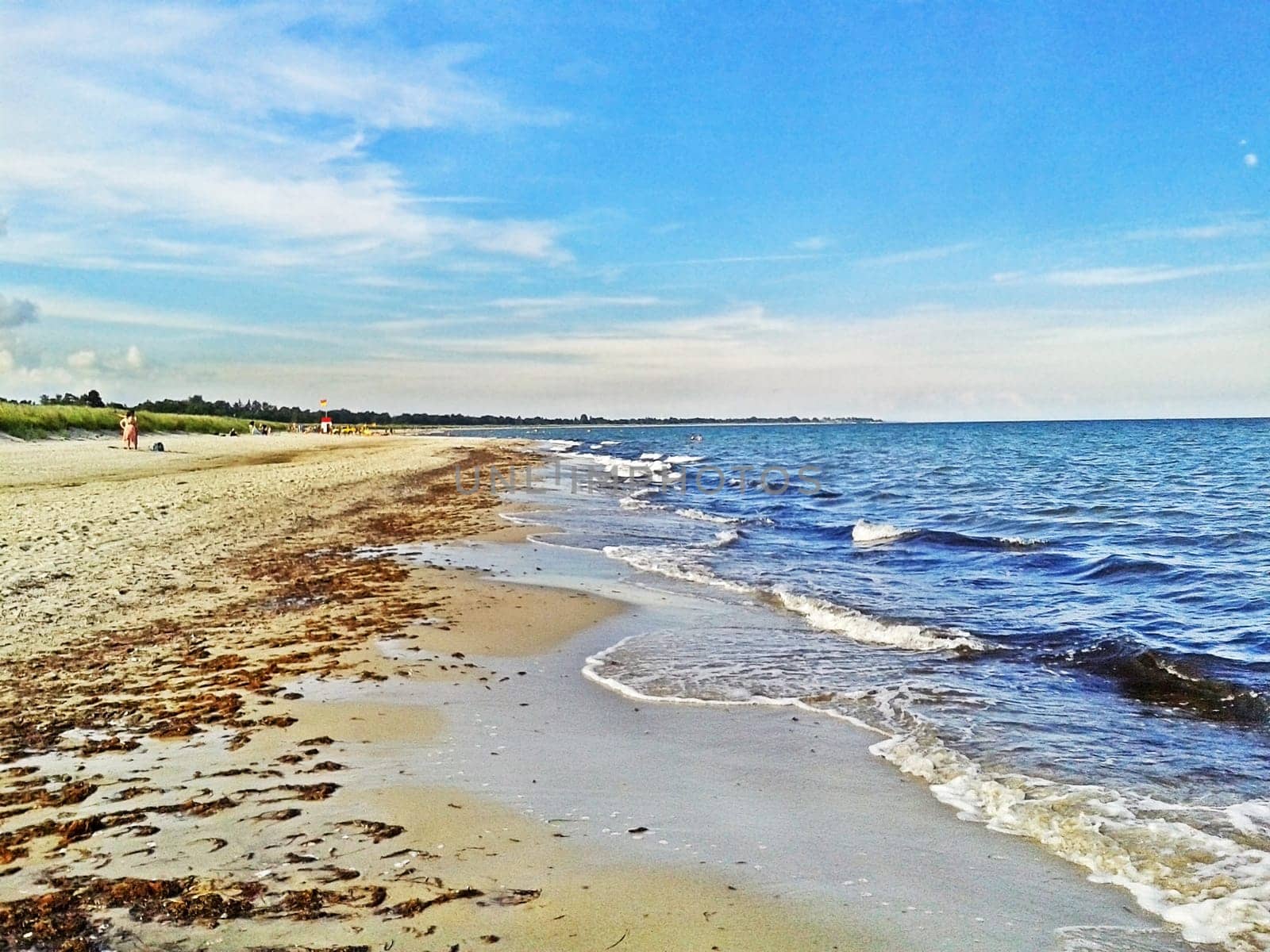 Beach in Marielyst, denmark with ocean waves of baltic sea and blue sky