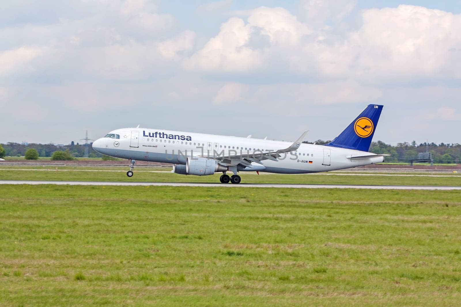 Stuttgart, Germany - April 29, 2017: Airbus airplane A320 200 from Lufthansa on landing approach at airport Stuttgart - runway and green meadow in front