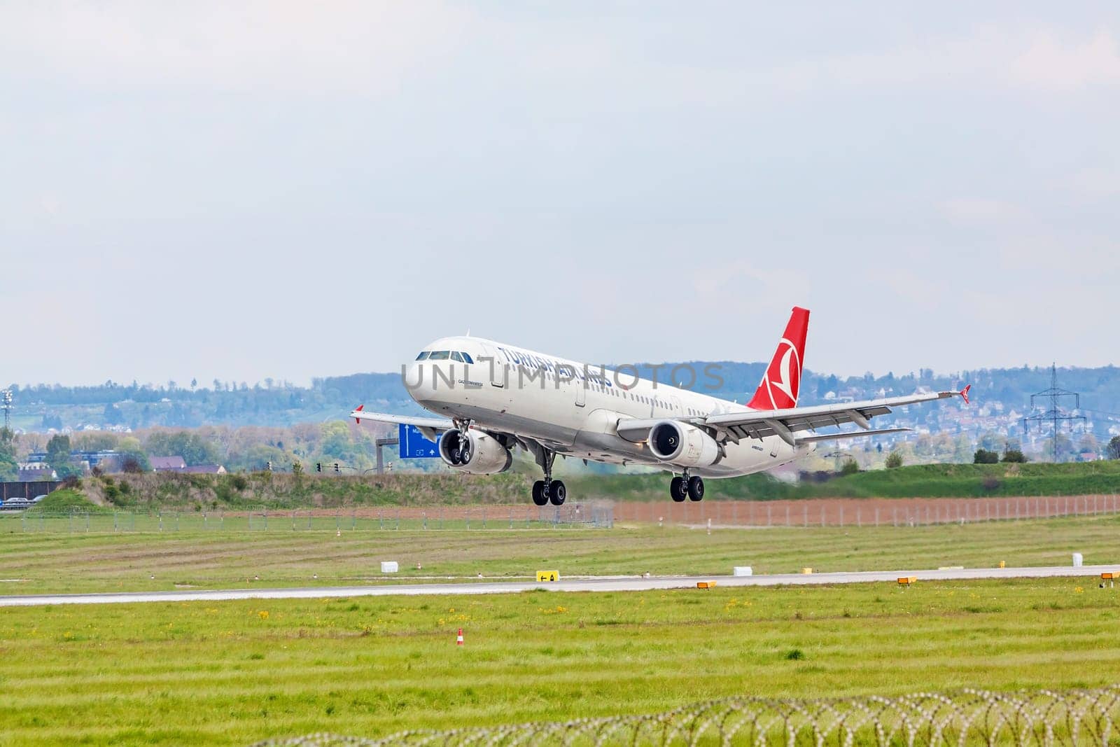Stuttgart, Germany - April 29, 2017: Airbus airplane A321 from Turkish Airlines on landing approach at airport Stuttgart - runway and green meadow in front
