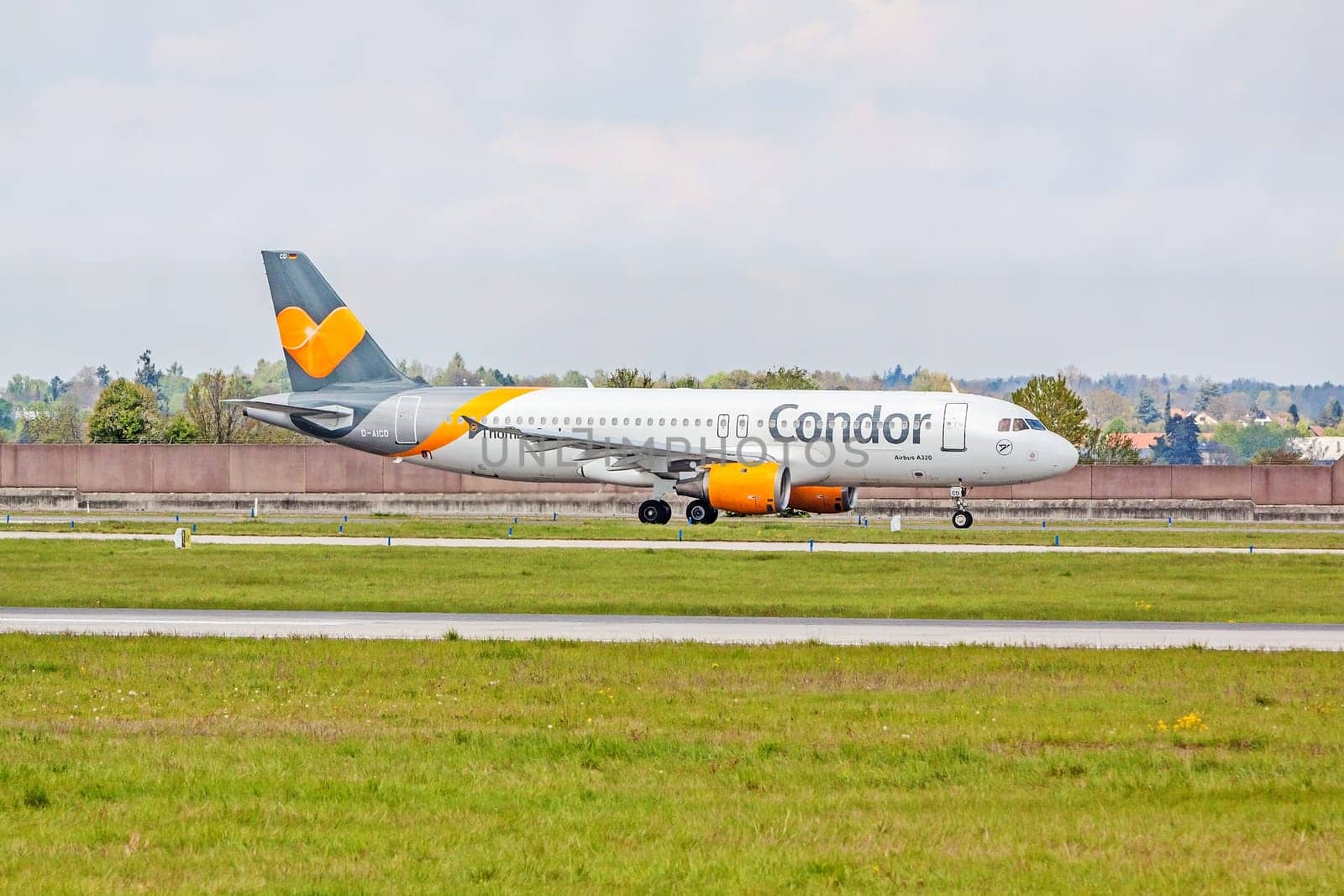 Stuttgart, Germany - April 29, 2017: Airbus airplane A320 from Condor at ground (airport Stuttgart) before take off - green meadow with fence in front
