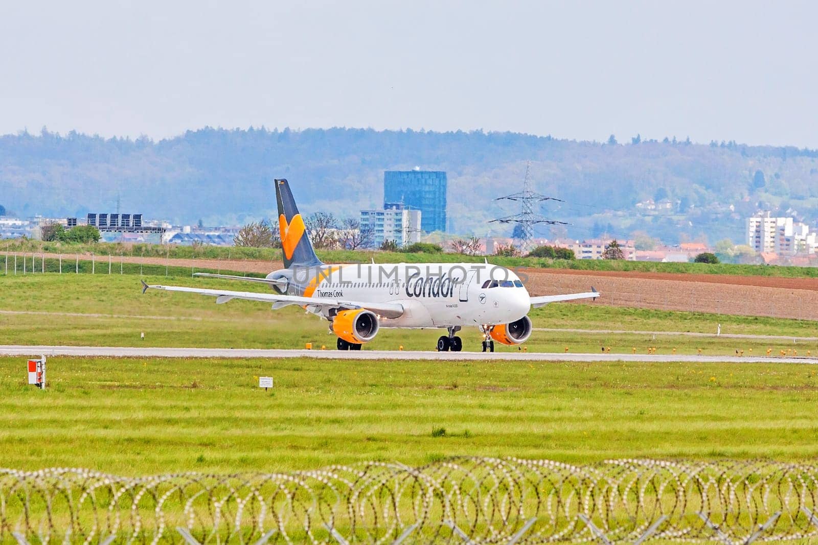 Stuttgart, Germany - April 29, 2017: Airbus airplane A320 from Condor at ground (airport Stuttgart) before take off - green meadow with fence in front