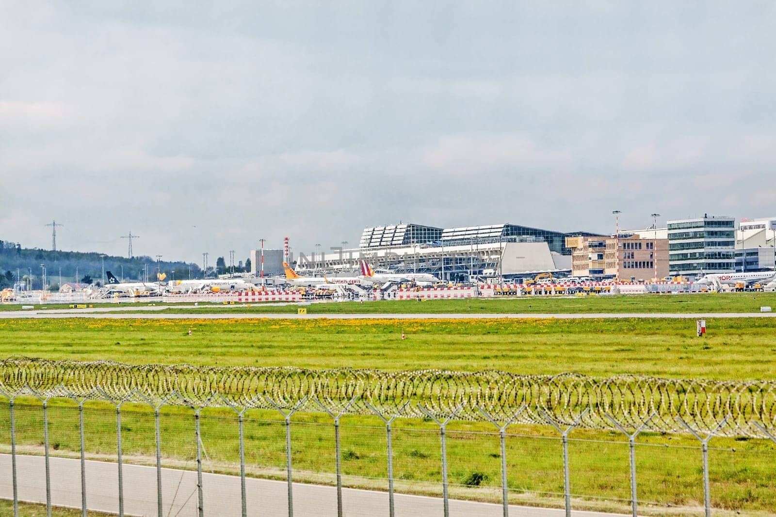Stuttgart, Germany - May 06, 2017: Airport Stuttgart (Manfred-Rommel-Flughafen), Terminal, exterior view with airplanes in parking position, runway in front
