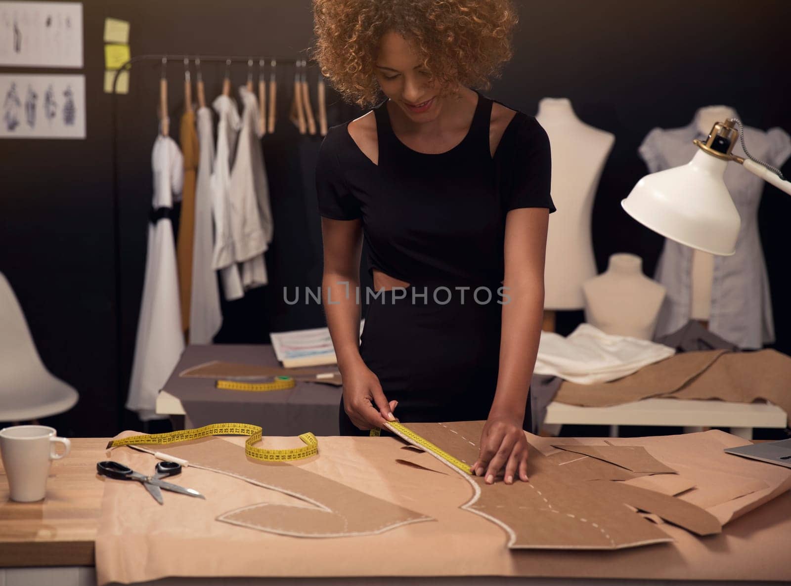 Portrait of a young fashion designer working on her atelier