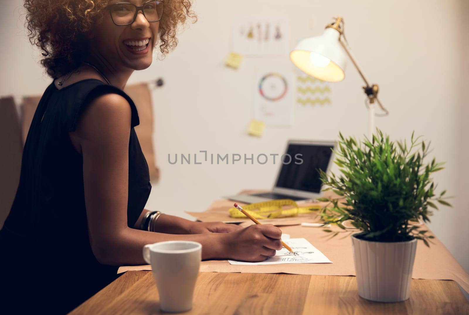 Portrait of a young fashion designer working on her atelier