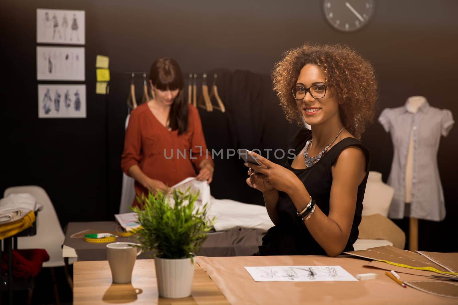 Two young entrepreneur women, and fashion designer working on her atelier