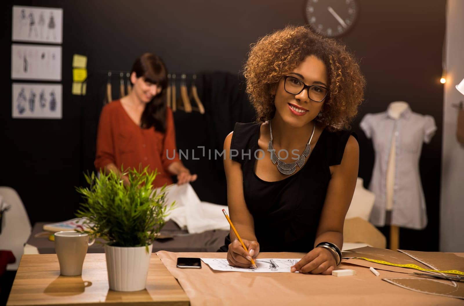 Two young entrepreneur women, and fashion designer working on her atelier