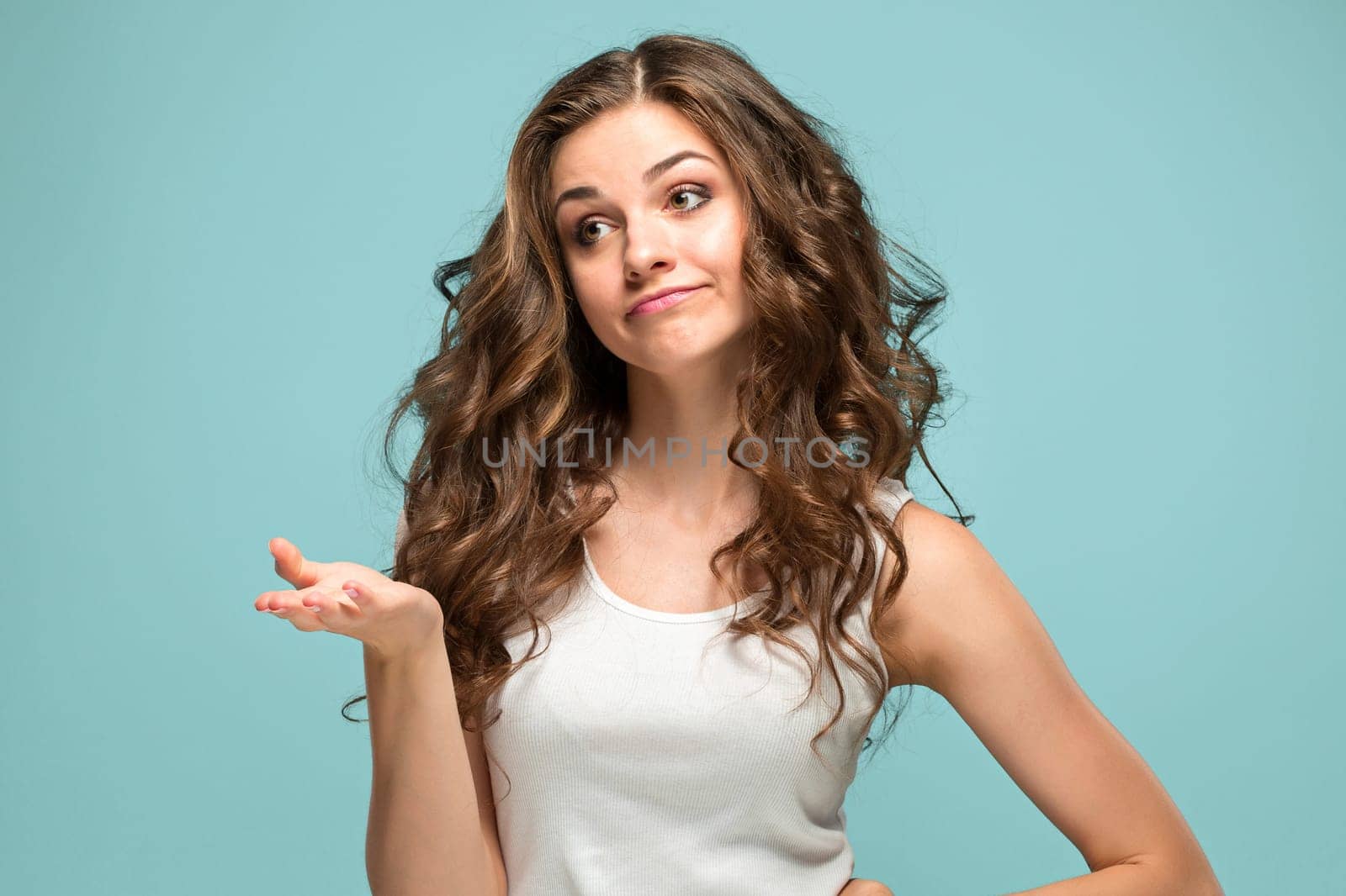 The young woman's portrait with sad emotions at studio Presenting something