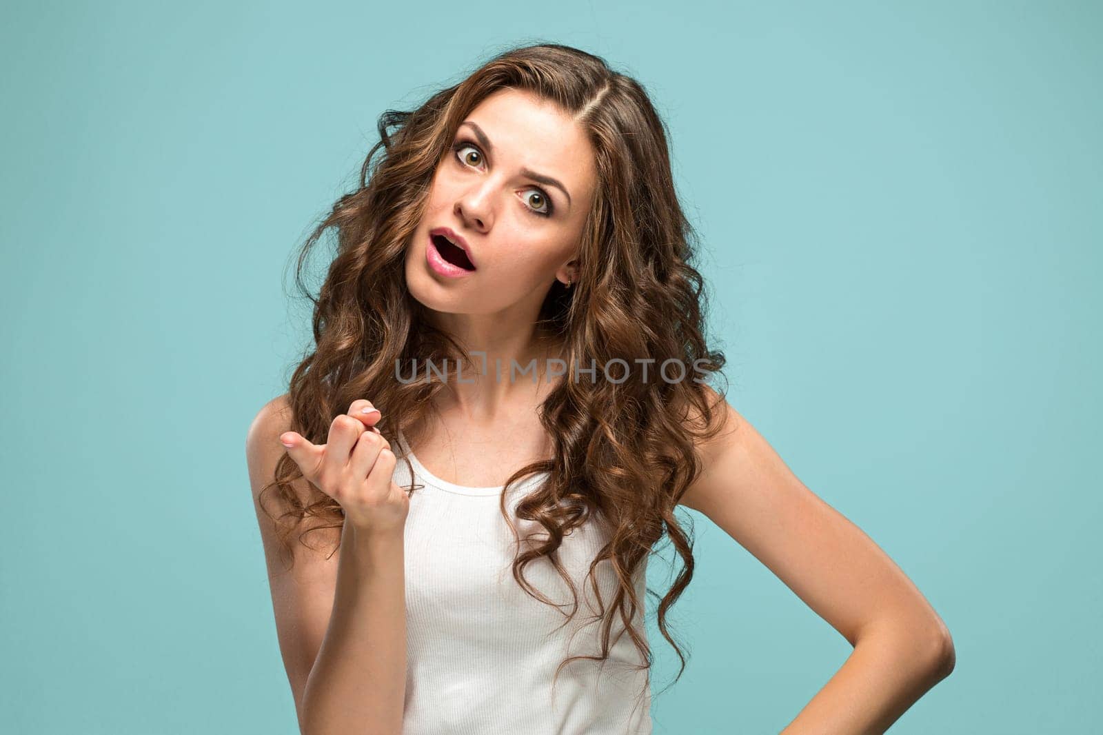 Portrait of an angry woman looking at camera isolated on a blue background