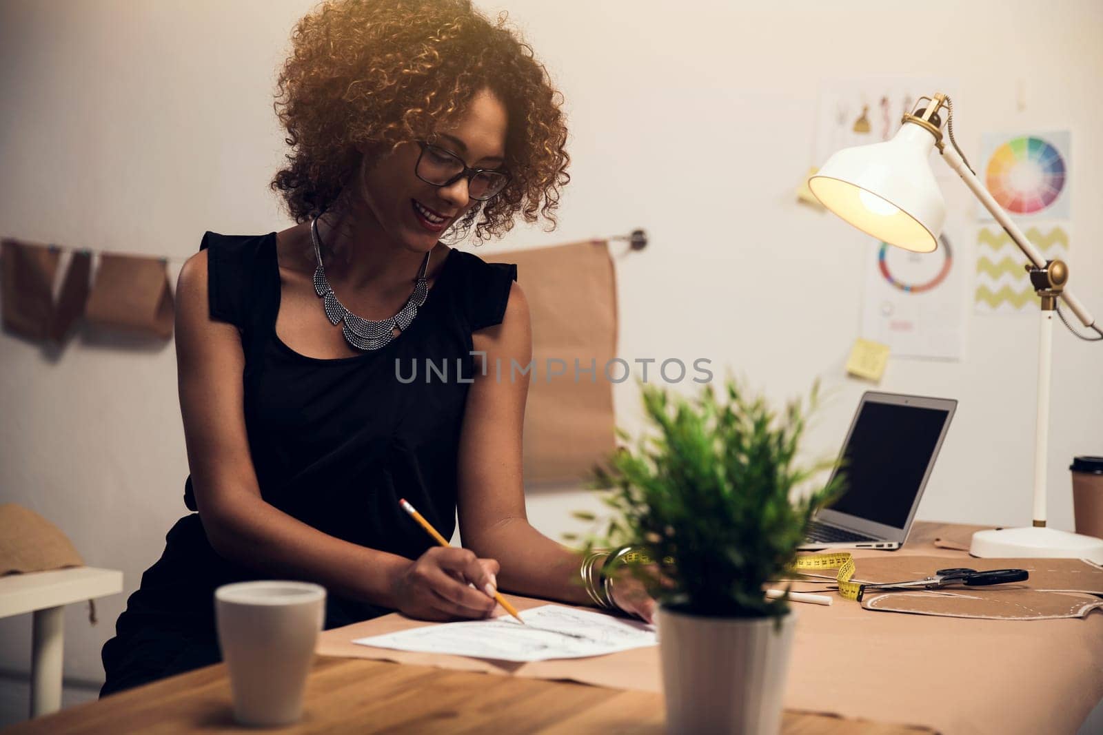 Portrait of a young fashion designer working on her atelier