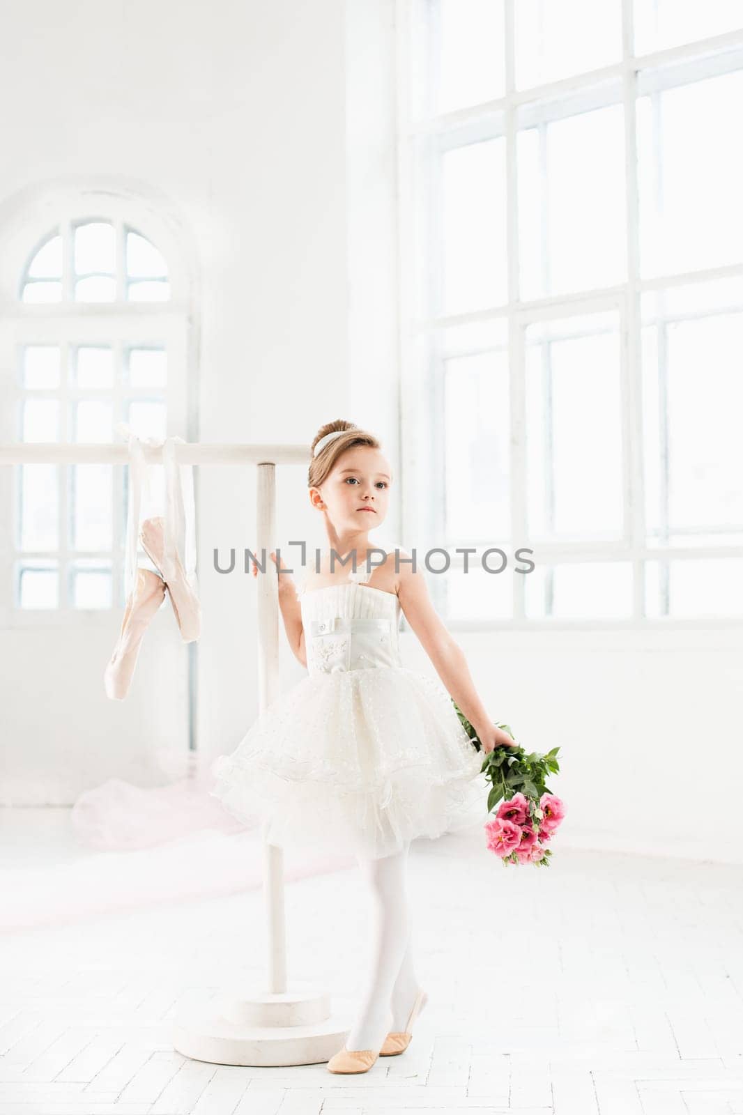 Little ballerina girl in a tutu. Adorable child dancing classical ballet in a white studio. Children dance. Kids performing. Young gifted dancer in a class. Preschool kid taking art lessons.