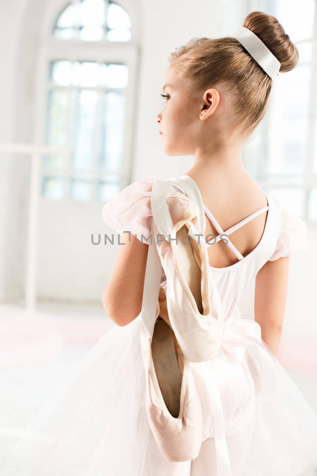 Little ballerina girl in a tutu. Adorable child dancing classical ballet in a white studio. Children dance. Kids performing. Young gifted dancer in a class. Preschool kid taking art lessons.