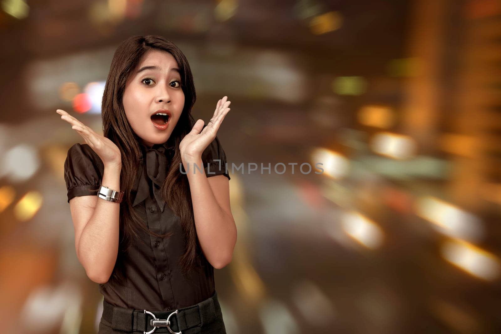 Excited asian woman celebrating Black Friday against blured lights background