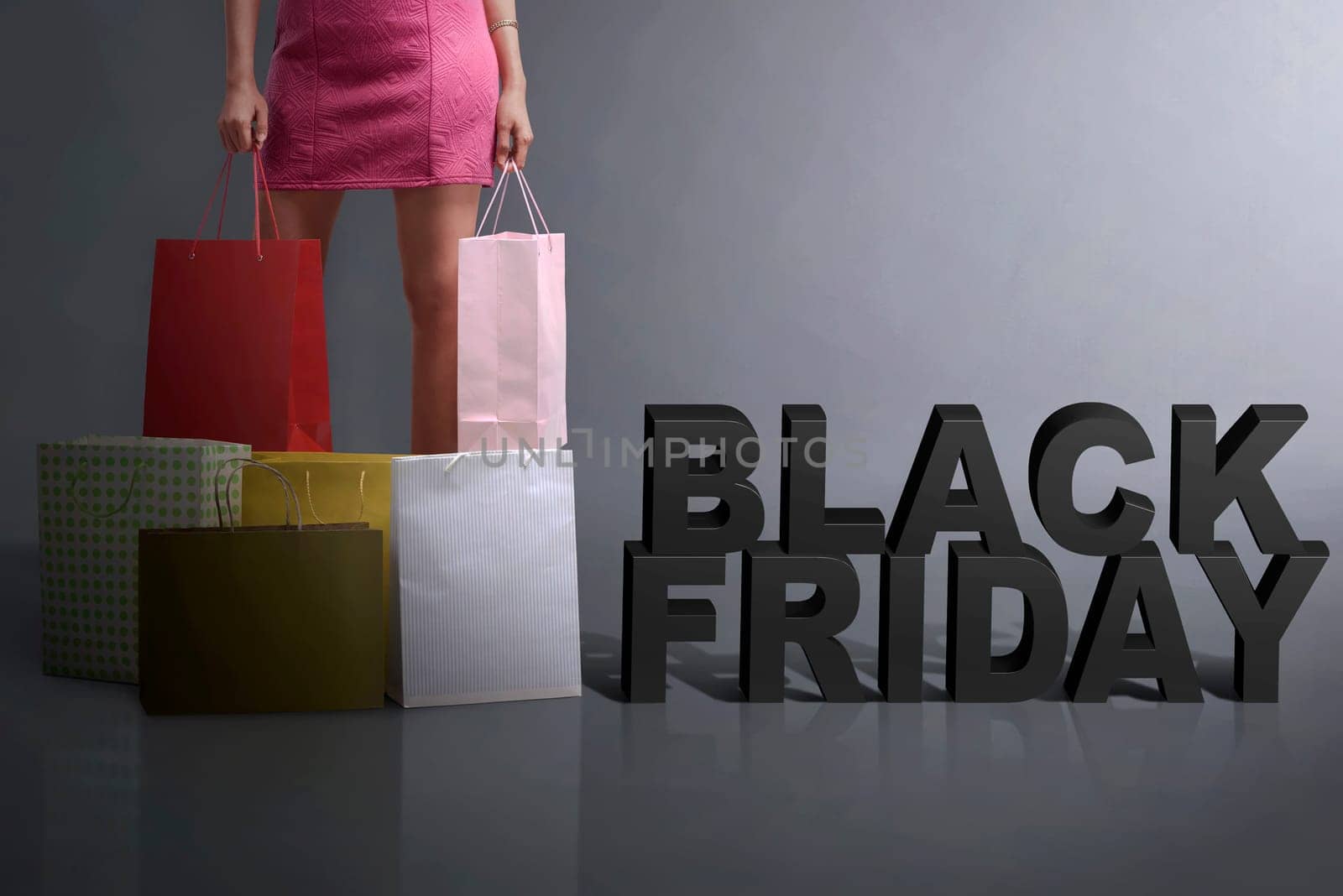 Young shopper holding shopping bag standing with Black Friday text over black background