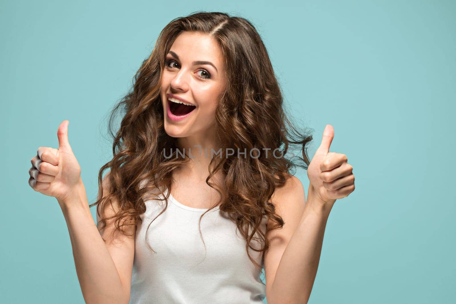 The young woman's portrait with happy emotions on gray background