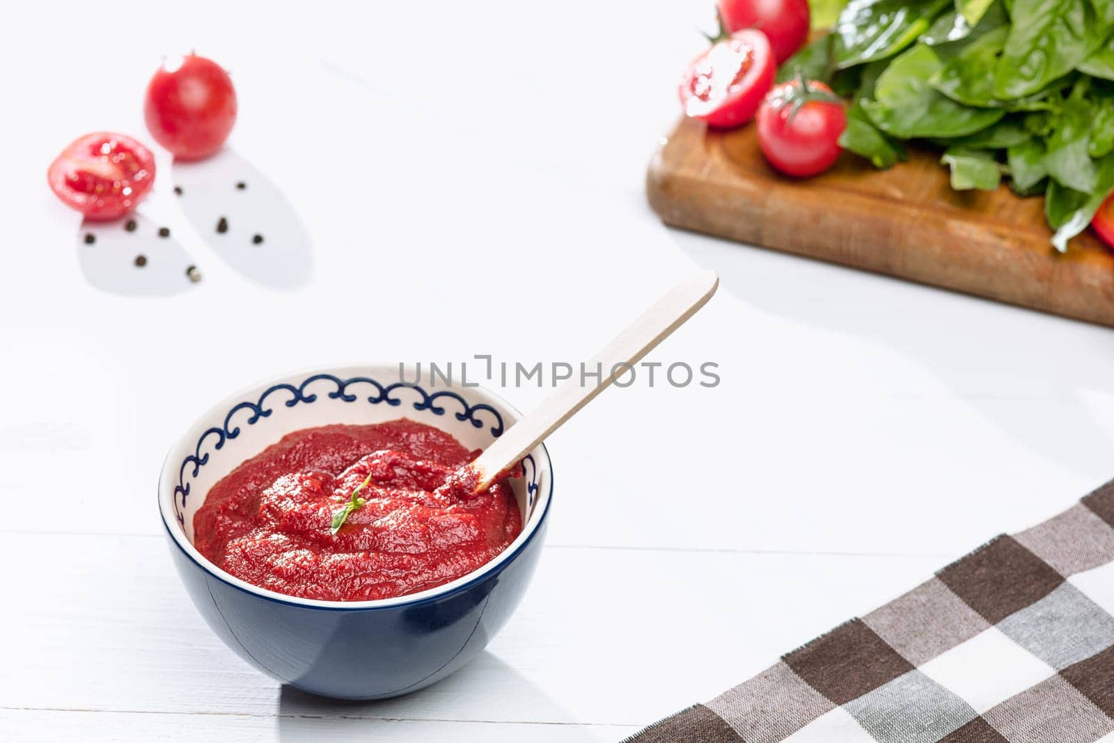 Bowl of chopped tomatoes on rustic table. Next to fresh whole tomatoes