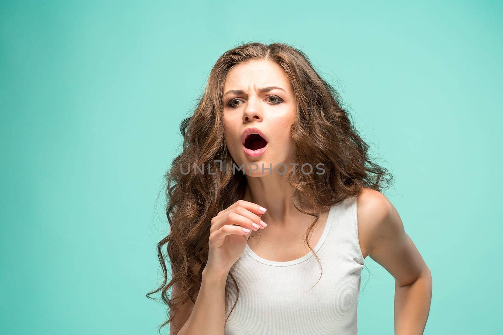 The portrait of alarmed young woman with shocked facial expression